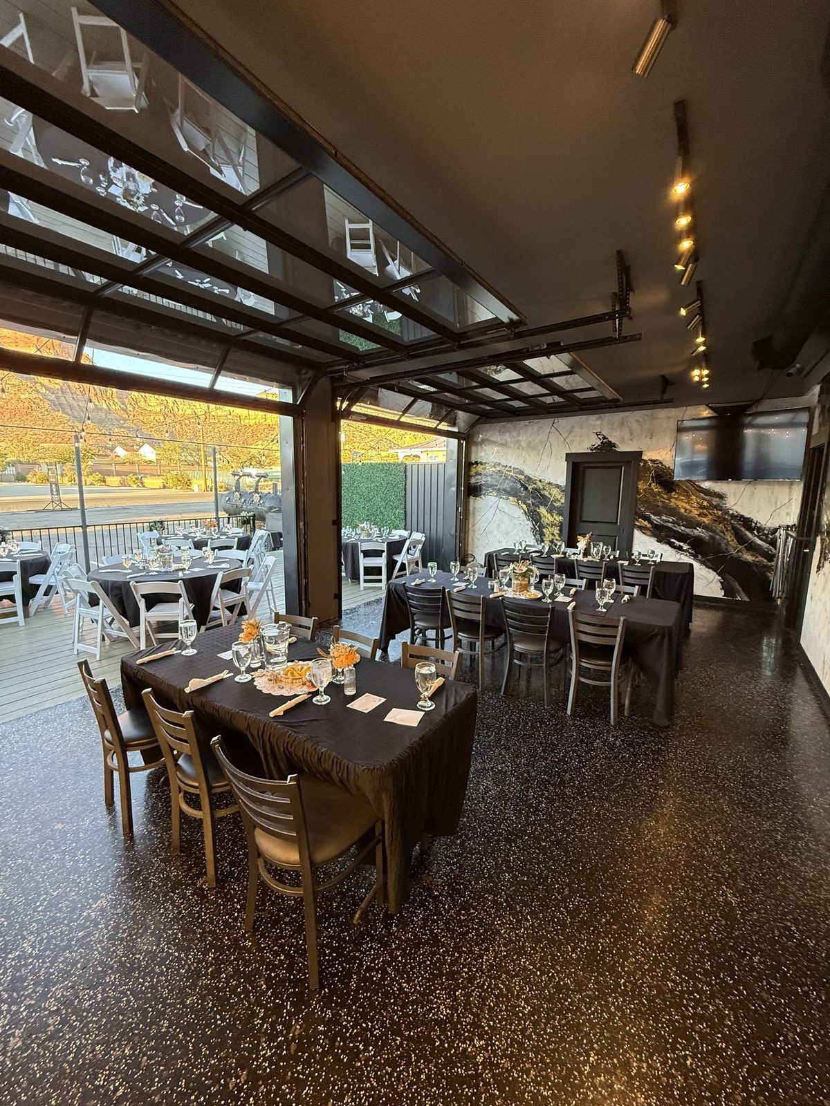 Covered dining area with garage-door windows