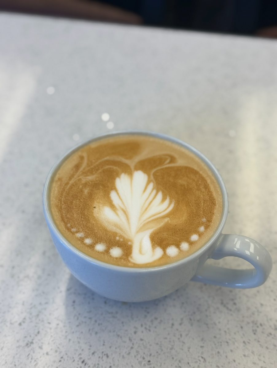 Latte with tulip latte art on a speckled counter