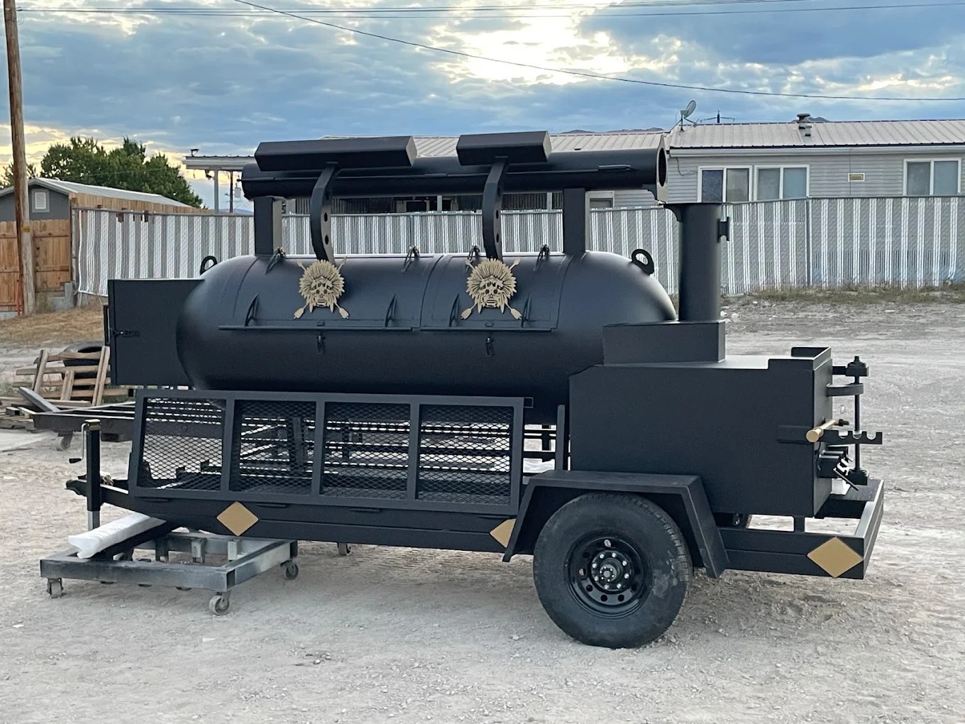El Cappuccino’s custom black trailer smoker with gold emblems and a tall smokestack